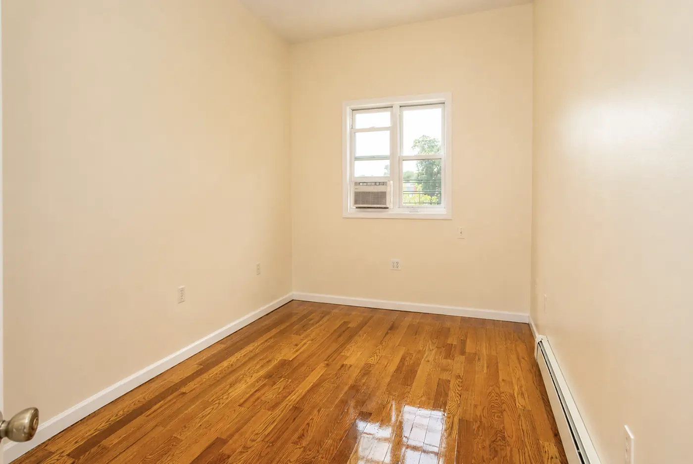 Second bedroom with a window looking out to trees