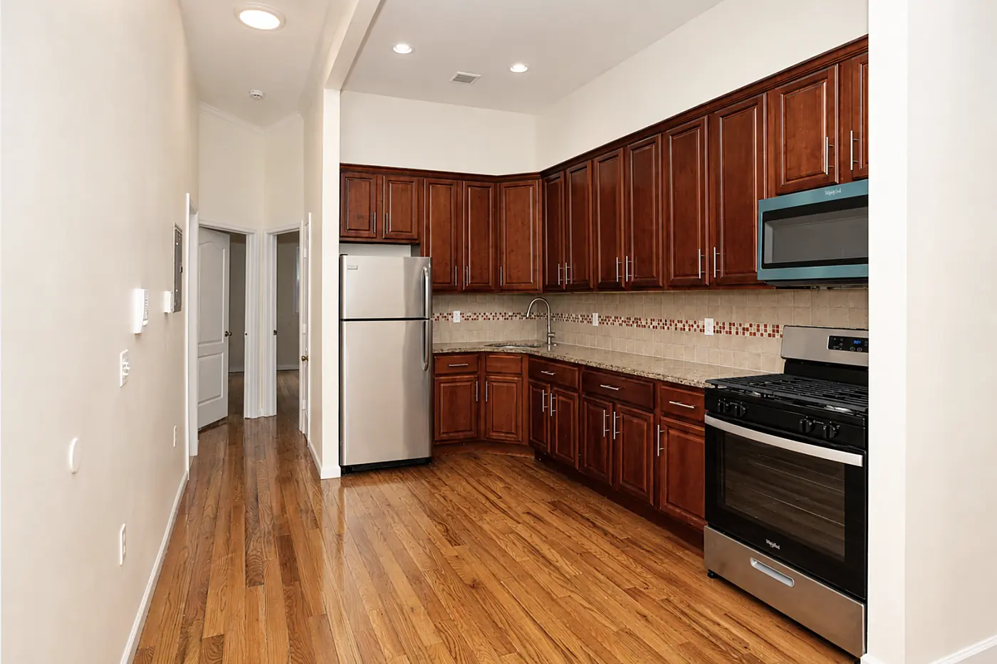 Kitchen with cherry cabinets, stainless steel appliances and a gas range