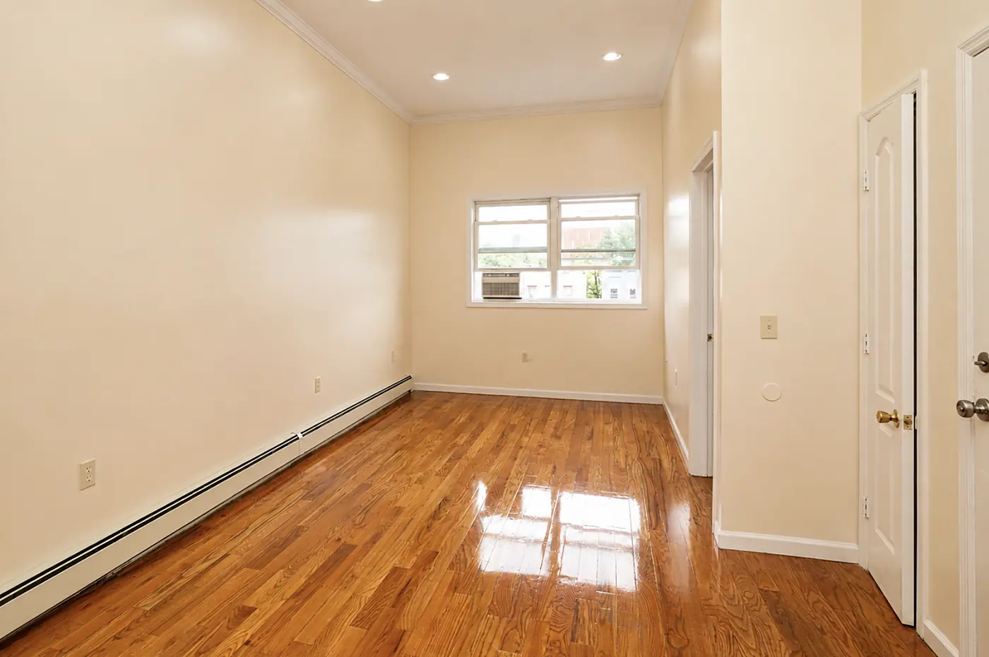 Living room with crown molding, recessed lighting and hardwood floors